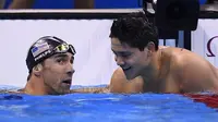 Perenang Singapura, Joseph Schooling (kanan), mengalahkan Michael Phelps (kiri) dalam perebutan medali emas nomor 100 meter gaya kupu-kupu putra Olimpaide 2016 di Olympic Aquatics Stadium, Rio de Janeiro, Jumat (12/8/2016). (AFP/Gabriel Bouys)