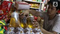 Pedagang tengah menata minyak curah yang dijual di pasar di Kota Tangerang, Banten, Kamis (25/11/2021). Hal ini dilakukan untuk mengantisipasi adanya lonjakan harga di komoditas minyak goreng. (Liputan6.com/Angga Yuniar)