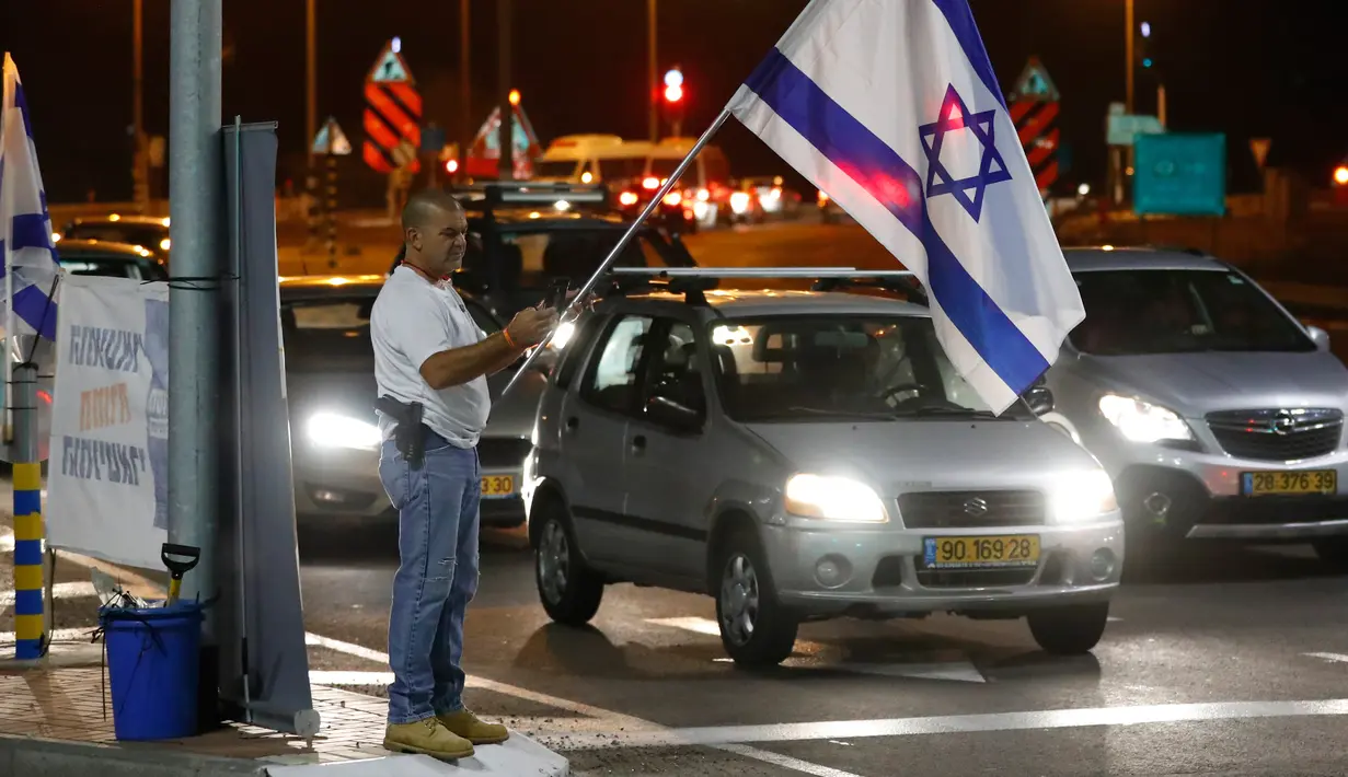 Warga berdemonstrasi menentang gencatan senjata dengan Hamas di Kota Ashkelon Selatan, Israel, Rabu (14/11). Gencatan senjata di Jalur Gaza dilakukan setelah terjadi pertempuran sengit selama dua hari. (JACK GUEZ/AFP)