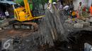 Alat berat mengangkat besi Jembatan Inspeksi Kali Grogol yang ambles di Komplek Hankam, Slipi, Jakarta, Senin (21/3). Dinas Pemprov DKI sedang melakukan perbaikan di kawasan depan Komplek HANKAM slipi Jakarta Barat. (Liputan6.com/Faisal R Syam)