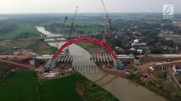 Foto udara pengerjaan Jembatan Kalikuto di Gringsing, Kabupaten Batang, Jawa Tengah, Senin (11/6). Menteri PUPR Basuki Hadimuljono mengatakan, jembatan pelengkung baja ini merupakan pertama di Indonesia. (Liputan6.com/Arya Manggala)