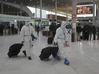 Penumpang dari Taiwan yang mengenakan APD lengkap tiba di Bandara Paris Charles de Gaulle di Roissy, Paris, Senin (1/2/2021). Prancis telah menutup perbatasannya untuk mayoritas negara non-Uni Eropa akibat situasi pandemi dan kekhawatiran penyebaran varian baru Covid-19.  (AP Photo/Francois Mori)