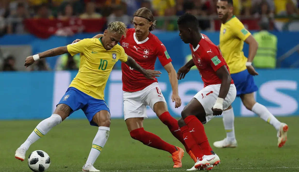 Striker Brasil, Neymar, berusaha melewati kepungan pemain Swiss pada laga Grup E Piala Dunia di Rostov Arena, Rostov-on-Don, Minggu (17/6/2018). Kedua negara bermain imbang 1-1. (AP/Darko Vojinovic)