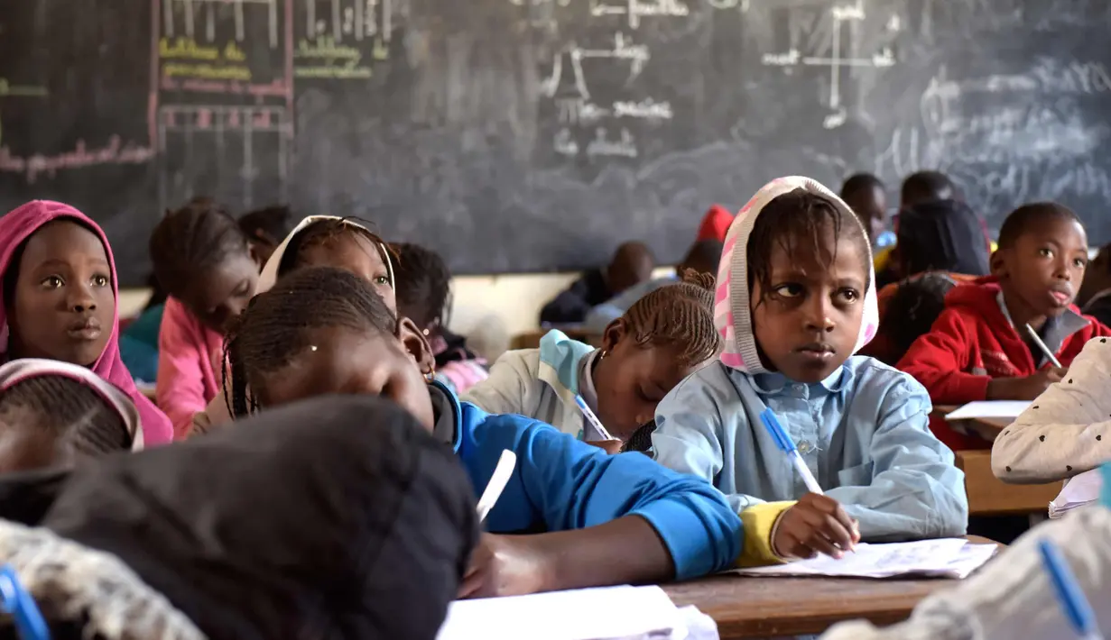 Murid menulis di buku saat menghadiri kelas di sekolah dasar di Pikine, Dakar, (30/1). Pendidikan di Senegal menjadi prioritas saat konferensi ketiga tentang pemulihan dana Kemitraan Global untuk Pendidikan (GPE) mulai 1 Februari 2018. (AFP Photo/Seyllou)