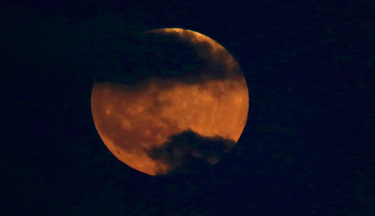 Bulan tampak berwarna merah darah saat terjadinya fenomena gerhana bulan total  di atas langit Tel Aviv, Israel,, Jumat (27/7). Gerhana bulan terlama pada abad ini dapat disaksikan di seluruh dunia dengan mata telanjang. (AP/Ariel Schalit)