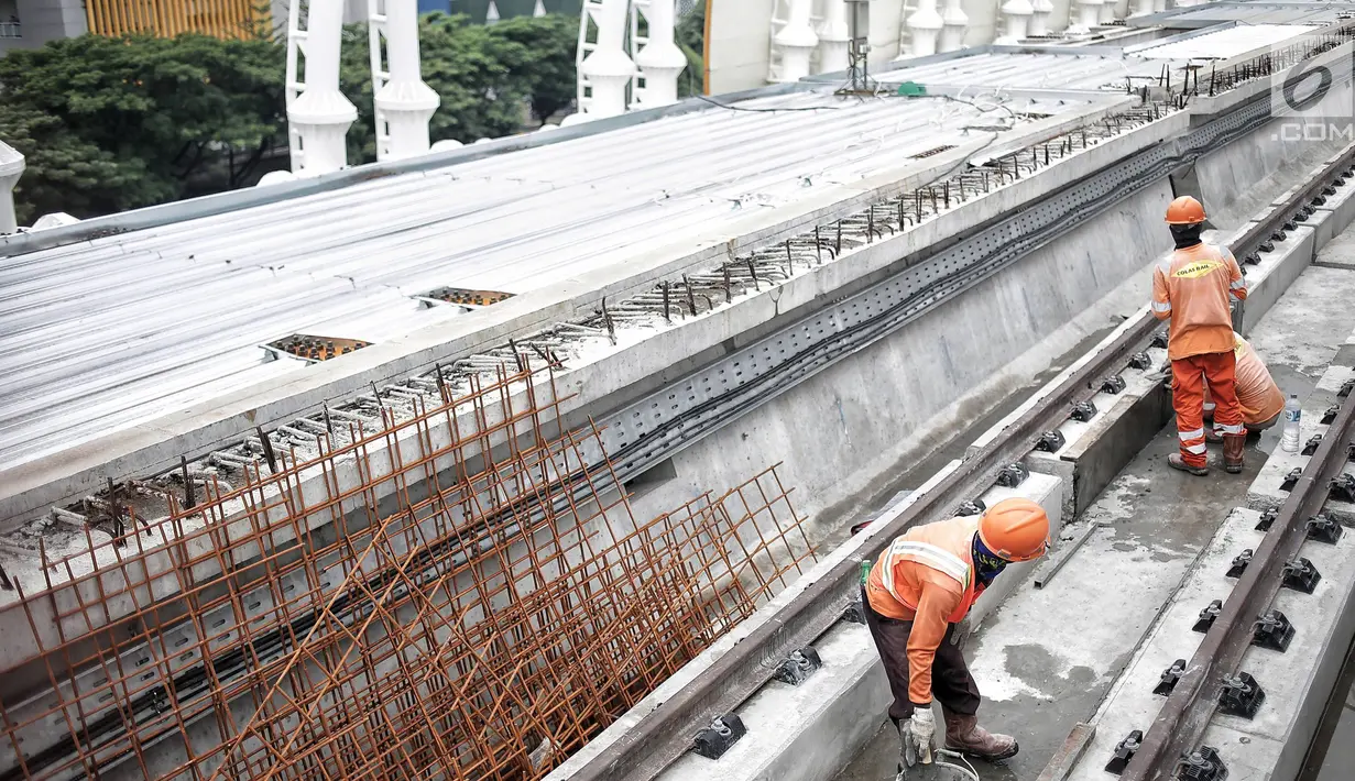 Pekerja menyelesaikan proyek pembangunan Light Rail Transit (LRT) Jabodebek di Stasiun LRT TMII, Jakarta, Senin (14/1). Stasiun LRT TMII yang dibangun dua lantai sudah mencapai 40%. (Liputan6.com/Faizal Fanani)