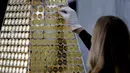 Karyawan rumah emas ProAurum menyusun koin emas yang disebut sebagai pohon Natal di Munich, Jerman, 3 Desember 2018. Pohon Natal ini terbuat dari 2.018 koin emas filharmonik wina senilai 2.3 euro atau sekitar 370 milliar rupiah. (AP/Matthias Schrader)