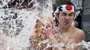 Penganut Shinto setengah telanjang menuangkan air dingin ke tubuhnya saat festival ketahanan dingin tahunan di Kuil Kanda Myojin Shinto, Tokyo, Jepang, Sabtu (18/1/2020). Menyiramkan air dingin ke tubuh diyakini dapat memurnikan jiwa mereka. (AP Photo/Eugene Hoshiko)