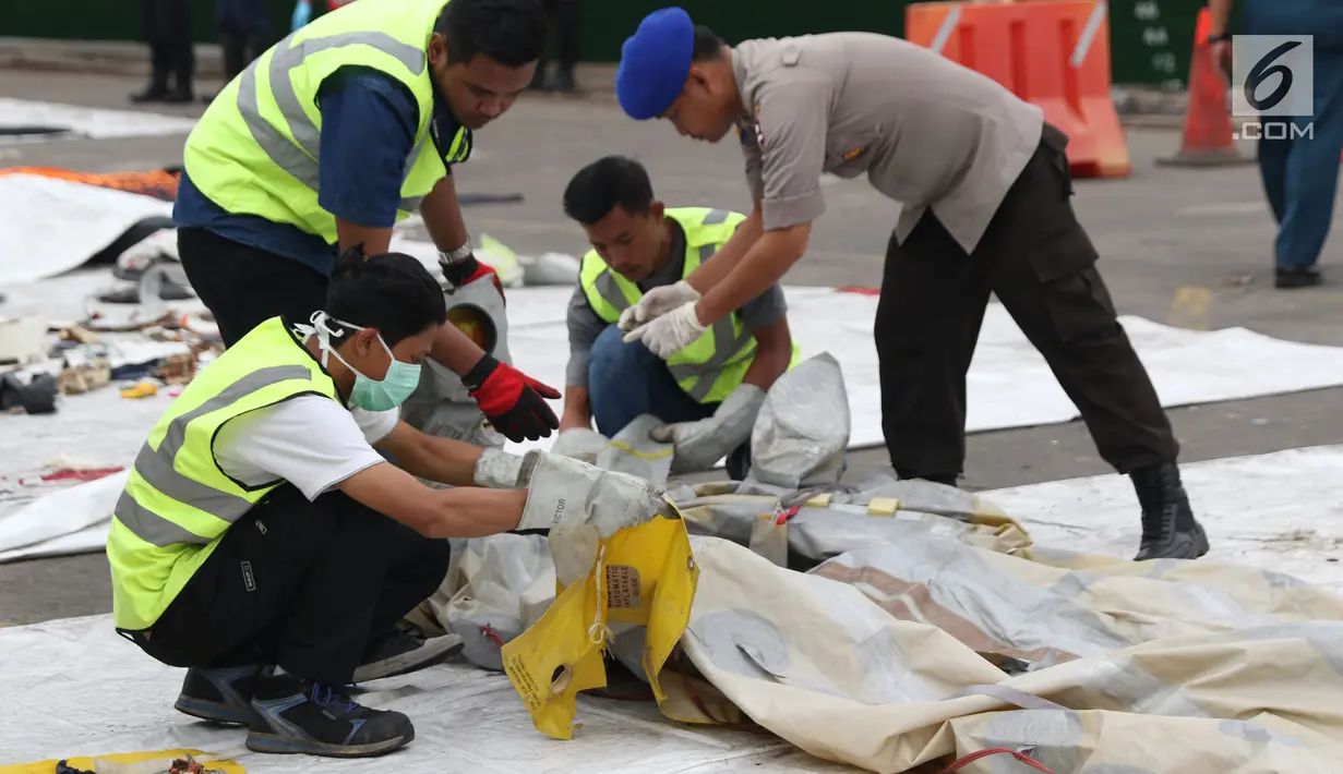 Petugas mengecek dan mengidentifikasi barang property pesawat Lion Air PK-LQP JT 610 di Pelabuhan JICT 2, Jakarta, Senin (5/11). Sejumlah barang ditemukan petugas gabungan dalam operasi pencarian. (Liputan6.com/Helmi Fithriansyah)