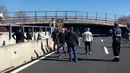 Sejumlah orang mengamati jembatan roboh di Ancona yang melintang di atas ruas jalan tol di wilayah pesisir pantai Italia, Kamis (9/3). Ruas jalan tol Ancona itu ditutup di kedua arahnya untuk demi keselamatan warga. (HO/Polizia di Stato/AFP)