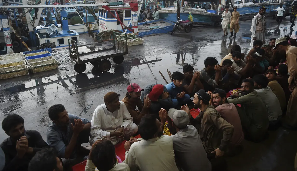 Nelayan berdoa sebelum berbuka puasa selama bulan suci Ramadhan di galangan kapal di kota pelabuhan Karachi, Pakistan pada 18 April 2022. Setelah menjalani ibadah puasa, waktu buka puasa menjadi momen yang dinanti oleh umat Islam. (Rizwan TABASSUM / AFP)