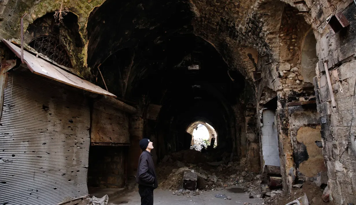 Seorang pria melihat kondisi bangunan pasar lama di kota tua Aleppo, Suriah (18/1). Perang di Aleppo telah mereda lebih dari setahun yang lalu, namun kondisi bangunan di pasar ini masih belum pulih. (AP Photo/Hassan Ammar)