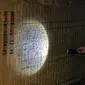 Seorang arkeolog memegang lampu senter di dinding yang ditutupi ukiran hieroglif di makam Beti, salah satu dari lima makam Firaun kuno di situs arkeologi Saqqara, Kairo, Mesir (19/3/2022). Menurut Waziri, lima makam yang semuanya dalam kondisi baik itu milik petinggi kerajaan. (AFP/Khaled Desouki)