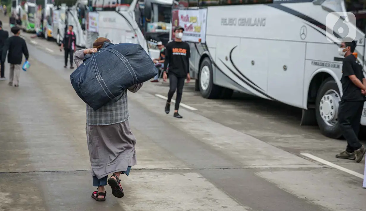 <p>Peserta Mudik Aman Mudik Sehat Kementerian Perhubungan memanggul barang bawaan berjalan menuju bus tujuan kampung halamannya di Terminal Jatijajar, Depok, Jawa Barat, Kamis (28/4/2022). Sekitar 3.000 penumpang diberangkatkan dengan 106 bus yang telah disiapkan oleh Dirjen Darat Kementerian Perhubungan. (Liputan6.com/Faizal Fanani)</p>