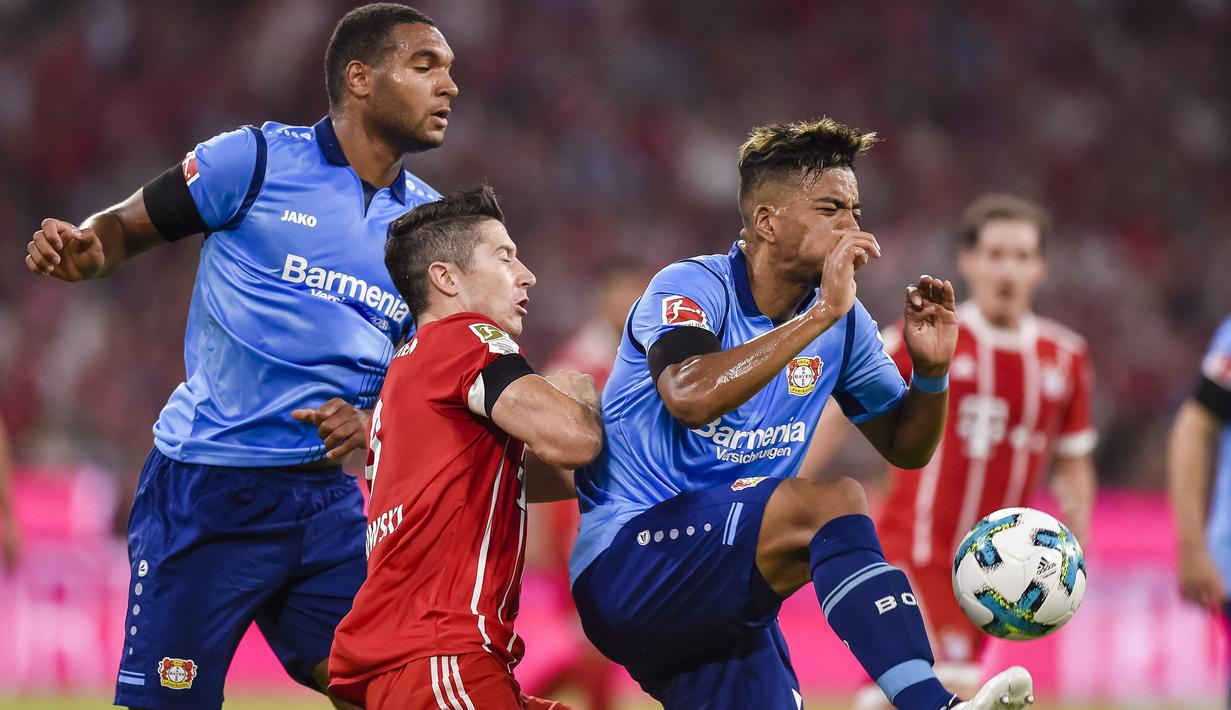 Pemain Bayern Munchen, Robert Lewandowski (tengah) berebut bola dengan para pemain Leverkusen pada laga Bundesliga di Allianz Arena, Munich,  (18/8/2017). Bayern menang 3-1. (AFP/ Guenter Schiffmann)