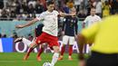 Robert Lewandowski. Striker Polandia yang total mencetak 2 gol di Piala Dunia 2022 Qatar ini menjadi pemain tertua kelima yang mampu mencetak gol pada Piala Dunia 2022 Qatar yang menjadi Piala Dunia keduanya. Gol keduanya dicetak melalui eksekusi penalti saat Polandia kalah 1-3 dari Prancis pada babak 16 besar (4/12/2022). Saat itu ia berusia 34 tahun, 3 bulan dan 14 hari. (AFP/Andrej Isakovic)