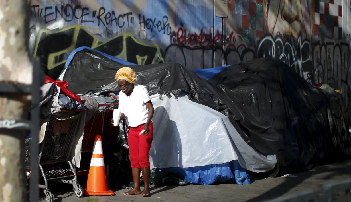 Seorang wanita keluar dari salah satu tenda yang ditempati kaum tunawisma di Skid Row, Los Angeles, California, Kamis (1/10/2015). Kota Los Angeles menetapkan status darurat terkait makin rumitnya persoalan kaum tunawisma di sana. (REUTERS/Lucy Nicholson)