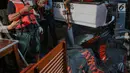 Petugas mengambil gambar kantong berisi jenazah dan serpihan pesawat Lion Air JT 610 yang jatuh di perairan Laut Utara Karawang, Jawa Barat saat dibawa menuju Posko Evakuasi, Tanjung Priok, Jakarta, Senin (29/10) malam. (Liputan6.com/Faizal Fanani)