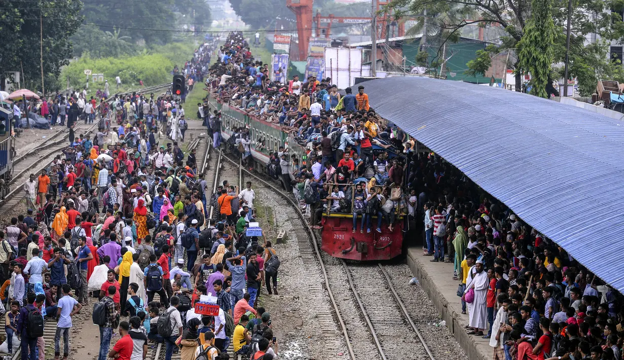 Ratusan penumpang duduk di atas atap kereta untuk menuju kampung halaman di Dhaka, Bangladesh pada 4 Juni 2019. Sebagaimana terjadi di Indonesia, masyarakat Bangladesh pun memiliki tradisi mudik saat Idul Fitri, namun agak membahayakan keselamatan. (MUNIR UZ ZAMAN/AFP)