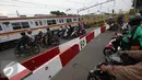 Salah satu bukti rendahnya tingkat kesadaran berlalu lintas yang baik di palang pintu perlintasan kereta di Kemayoran, Jakarta, Kamis (6/10). Pemotor menerobos palang pintu tanpa rasa takut tersambar kereta api lewat. (Liputan6.com/Immanuel Antonius)