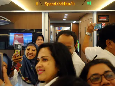 Para penumpang mengambil gambar dengan ponsel mereka saat naik Kereta Cepat Jakarta Bandung (KCJB), Minggu (17/9/2023). PT Kereta Cepat Indonesia China (KCIC) menjalankan uji coba operasional kereta cepat secara gratis bagi masyarakat umum. (merdeka.com/Arie Basuki)