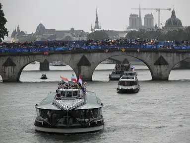 Kontingen Indonesia bersama kontingen India dan Iran berlayar di atas perahu saat upacara pembukaan Olimpiade Paris 2024 di Sungai Seine, Paris Prancis, 26 Juli 2024. (AFP/Sebastien Bozon)