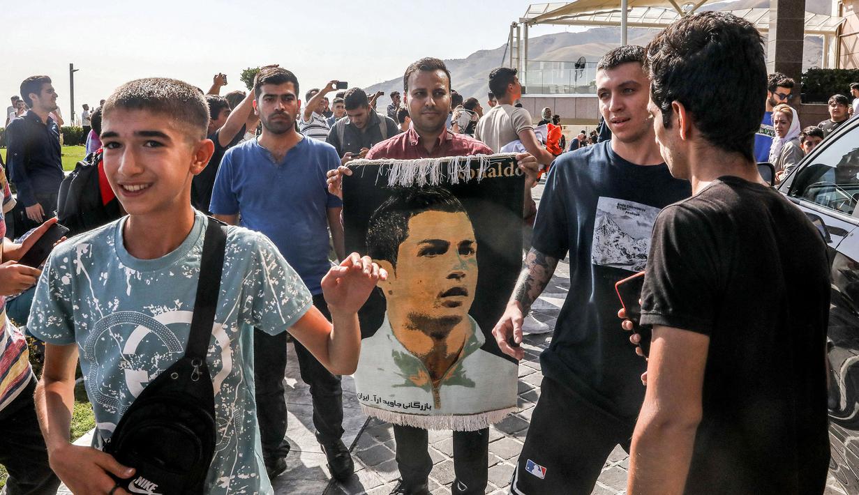 Sejumlah masyarakat Tehran membawa poster pemain Al-Nassr, Cristiano Ronaldo saat menyambut kedatangannya menjelang laga Liga Champions Asia 2023 melawan Persepolis FC, Selasa (19/09/2023). (AFP/Payam Parsae)