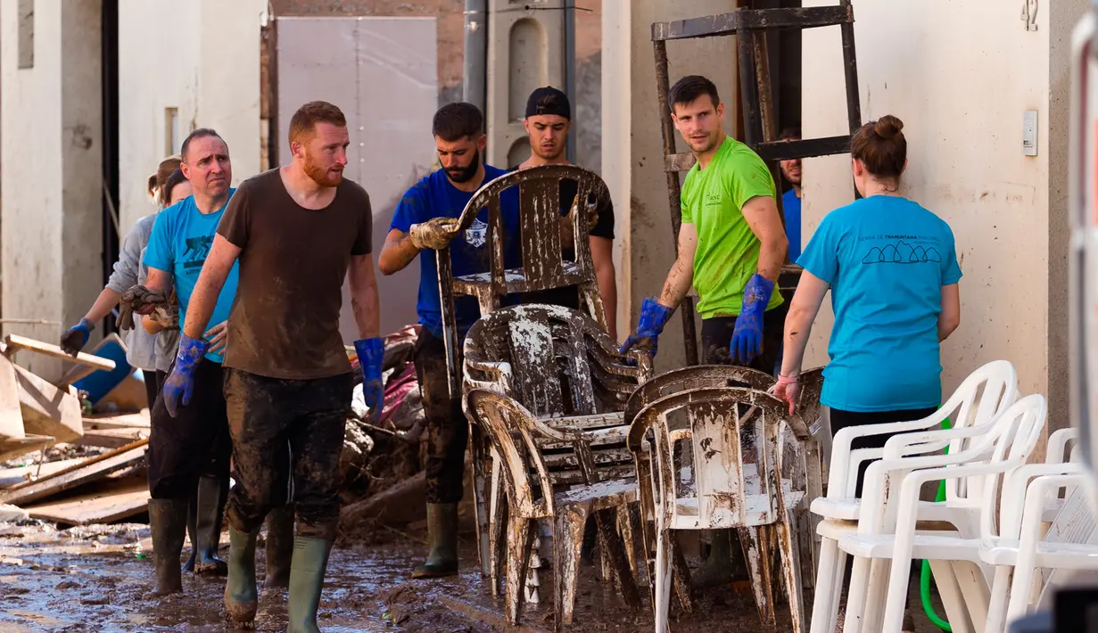 Sejumlah Warga membersihkan rumahnya yang terkena banjir bandang di Sant Llorenc, Mallorca, Spanyol (11/10). Banjir bandang tersebut telah menewaskan setidaknya 10 orang. (AP Photo/Francisco Ubilla)