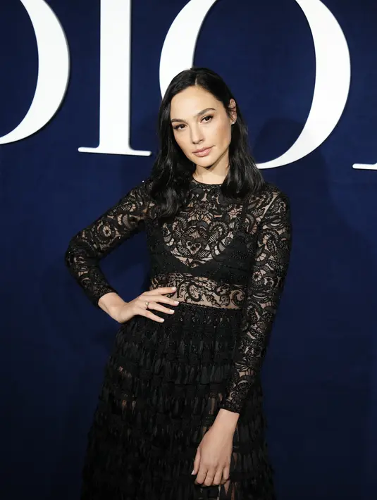 Gal Gadot berpose di depan koleksi ready-to-wear Christian Dior Fall/Winter 2023-2024 yang dipresentasikan di Paris  pada Selasa, 28 Februari 2023. Gal Gadot membuatnya tetap sederhana dalam hal aksesori dan kemewahan. Rambut hitamnya ditata dalam gelombang longgar sementara riasannya tetap minim namun glamor. (Vianney Le Caer/Invision/AP)