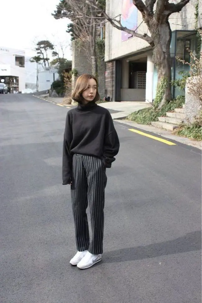 Korean style untuk busana kantor dengan sweater hitam berpotongan tinggi pada leher dipadukan bersama pants motif garis-garis lurus kebawah buat penampilan kamu terlihat menarik. (sumber foto: weheartit.com/pinterest)