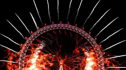 Kembang api menghiasi London Eye saat perayaan malam Tahun Baru 2019 di London, Inggris, Selasa (1/1). (AP Photo/Kirsty Wigglesworth)