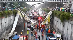 Petugas berusaha memotong bagian JPO yang roboh di Jalan Raya Pasar Minggu, Jakarta Selatan, Sabtu (24/09). Tiga unit mobil tertimpa akibat JPO yang jarang dipergunakan lagi. (Liputan6.com/Immanuel Antonius)