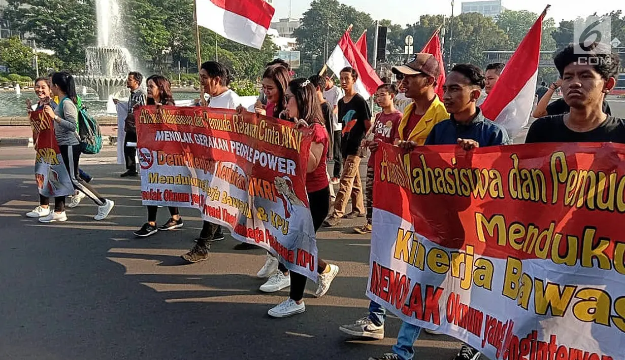 Aliansi Mahasiswa dan Pemuda Cinta NKRI membentangkan sejumlah spanduk berisi pesan ajakan untuk mendukung KPU dan Bawaslu pasca Pilpres 2019 saat car free day (CFD) di kawasan Thamrin, Jakarta, Minggu (19/5/2019). (Liputan6.com/Faizal Fanani)