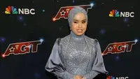 Di final AGT, Putri kembali mengenakan gaun rancangan Tiffany Liem. Kali ini, ia memilih gaun berwarna kebiruan yang memiliki ekor panjang hingga menyapu lantai. [@portalpageanti]
