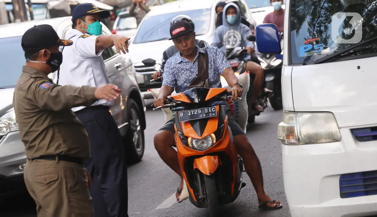 Petugas mengarahkan warga yang terjaring razia penggunaan masker di Kelurahan Sudimara Barat, Kota Tangerang, Kamis (27/5/2021). Mereka yang terjaring razia diminta untuk melakukan tes GeNose C19 guna mencegah penularan virus corona Covid-19. (Liputan6.com/Angga Yuniar)