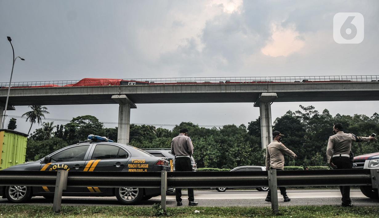 Petugas kepolisian saat berjaga di sekitar lokasi tabrakan kereta Light Rail Transit (LRT) di kawasan Munjul, Cibubur, Jakarta, Senin (25/10/2021). Dua rangkaian kereta LRT Jabodebek mengalami tabrakan saat tengah menjalani tahap uji coba pada pukul 12.30 WIB. (merdeka.com/Iqbal S Nugroho)