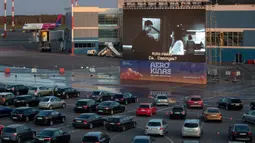 Sejumlah penonton duduk di mobil mereka saat menonton film di bioskop drive-in di area apron bandara , tempat pesawat lepas landas dan mendarat ketika bioskop biasa ditutup karena wabah virus Corona di Vilnius, Lithuania pada 29 April 2020. (AP/Mindaugas Kulbis)