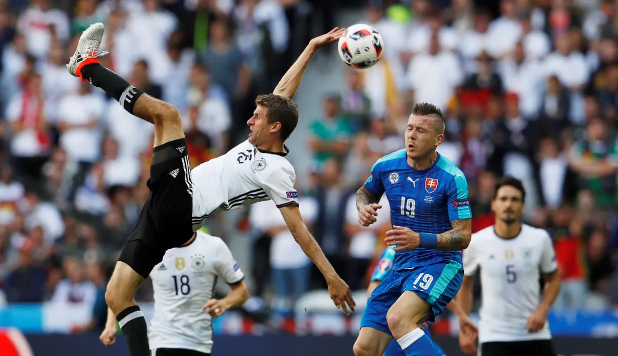 Pemain Jerman, Thomas Muller (kiri), berebut bola dengan pemain Slovakia, Juraj Kucka, pada laga 16 besar Piala Eropa 2016 di Stade Pierre Mauroy, Lille, Minggu (26/6/2016) malam WIB. (Reuters/Lee Smith)