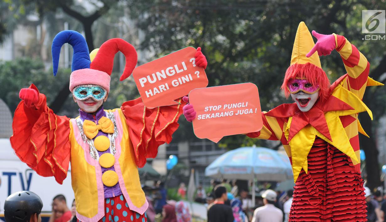 Badut menunjukkan tulisan saat social community gathering Satgas Saber Pungli di Jakarta, Minggu (17/9). Kemenko Polhukam meluncurkan maskot dan melakukan sosialisasi satgas saber pungli. (Liputan6.com/Helmi Fithriansyah) 