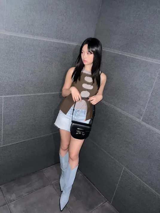 Ide outfit layering bergaya Y2k berikutnya bisa ditiru dari Hanni NewJeans. Padukan tanktop dengan sleeveless cut out top. Untuk bawahan bisa pilih denim shorts dan sepatu boots berbahan denim juga. [@newjeans_official]