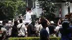 Bakal Calon Presiden, Prabowo Subianto berdiri di atas mobilnya dalam perjalanan menuju Gedung KPU RI, Jakarta, Jumat (10/8). Ketua Umum Gerindra Prabowo Subianto berangkat ke KPU untuk mendaftarkan diri sebagai capres. (Liputan6.com/Herman Zakharia)
