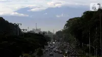 Kawasan gunung Gede-Pangrango terlihat samar menjadi latar belakang pemandangan di Jalan Benyamin Sueb, Kemayoran, Jakarta, Kamis (18/2/2021). Jika cuaca cerah, kawasan gunung Gede-Pangrango bisa terlihat dengan jelas dari atas jembatan layang Jalan HBR Motik. (Liputan6.com/Helmi Fithriansyah)