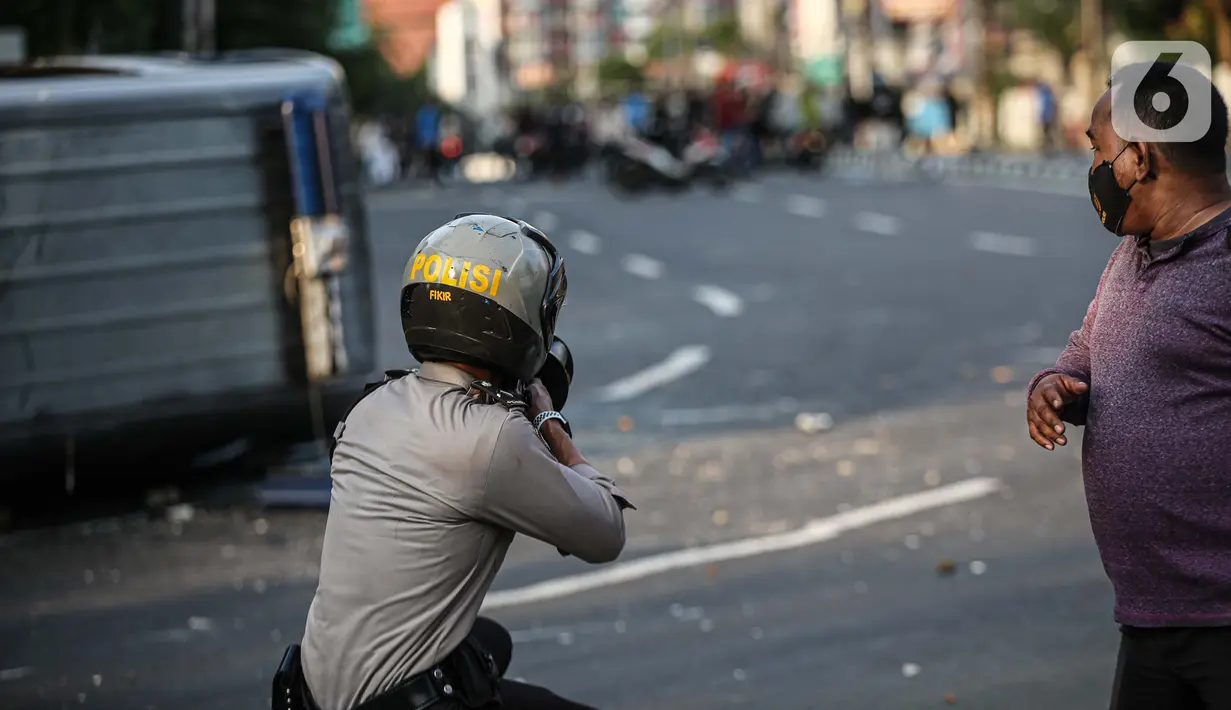Polisi menembak ke arah massa saat bentrok di kawasan Pejompongan, Jakarta, Rabu (7/10/2020). Belum bisa dipastikan apakah aksi tersebut berkaitan dengan isu aksi penolakan pengesahan UU Omnibus Law Cipta Kerja. (Liputan6.com/Faizal Fanani)