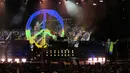 Aksi vokalis Scorpions, Klaus Meine (kanan) memegang bendera Ukraina dengan latar belakang layar besar tanda Perdamaian dalam warna bendera Ukraina yang ditampilkan selama konser di Stadion Tsirion Limassol, Siprus, Selasa (12/7/2022). (AP Photo/Petros Karadjias)
