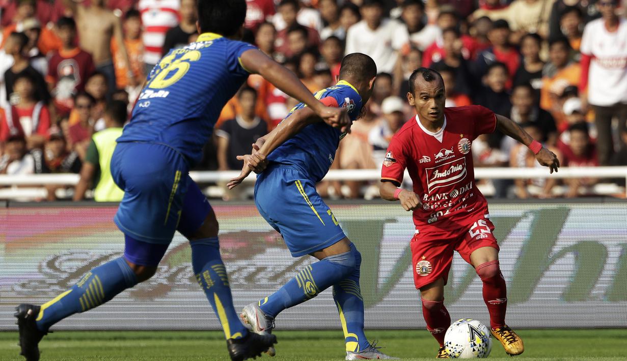 Gelandang Persija Jakarta, Riko Simanjuntak, berusaha melewati pemain Persib Bandung pada laga Shopee Liga 1 di SUGBK, Jakarta, Rabu (10/7). Persija bermain imbang 1-1 atas Persib. (Bola.com/Yoppy Renato)