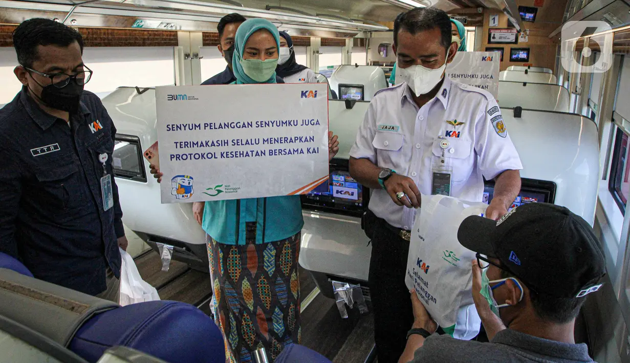 Petugas memberikan bingkisan kepada penumpang KA Taksaka di Stasiun Gambir, Jakarta, Sabtu (4/8/2021). Dalam rangka memperingati hari pelanggan nasional, PT KAI Daop 1 Jakarta membagikan ratusan bingkisan kepada penumpang kereta api. (Liputan6.com/Faizal Fanani)