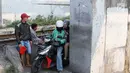 Pengendara sepeda motor melintasi jalan setapak di pinggir rel kereta di kawasan Tambora, Jakarta, Senin (10/7). Tidak tersedianya akses jalan untuk putar balik membuat warga terpaksa memanfaatkan jalan setapak tersebut. (Liputan6.com/Immanuel Antonius)