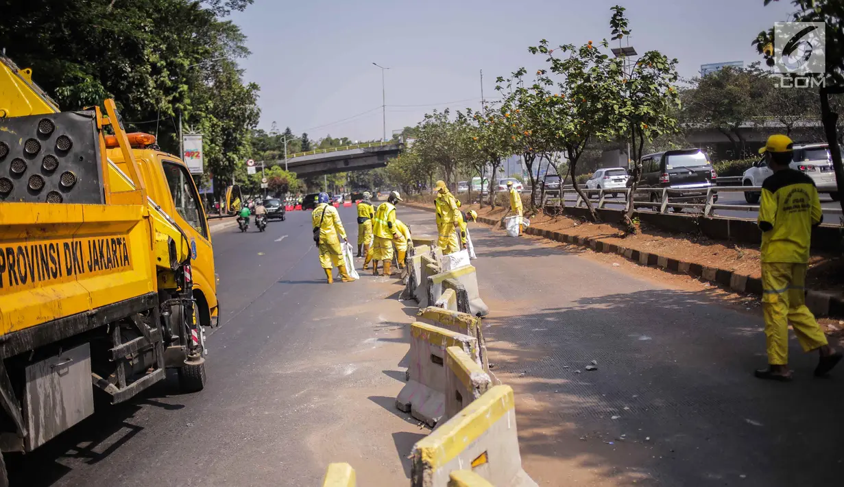 Petugas Dinas Bina Marga DKI Jakarta memperbaiki separator busway di kawasan Jalan Gatot Subroto, Jakarta, Selasa (1/10/2019). Separator busway dirusak massa saat terjadi bentrok antara polisi dengan demonstran di kawasan tersebut. (Liputan6.com/Faizal Fanani)