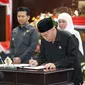 Khofifah  dan Emil  Dardak saat menandatangani berita acara pemberhentian sebagai gubernur dan wakil gubernur (wagub) Jawa Timur. (Istimewa).