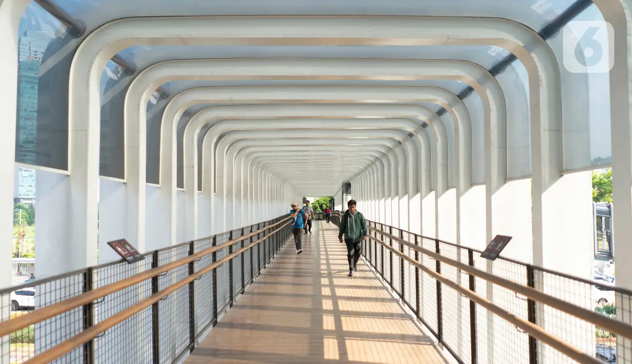 Pejalan kaki melintas di Jembatan Penyeberangan Orang (JPO) Bundaran Senayan, Jakarta, Jumat (15/11/2019). Untuk mencegah pengguna skuter listrik bermain di JPO, Dinas Bina Marga DKI menambahkan rambu larang melintas. (Liputan6.com/Immanuel Antonius)